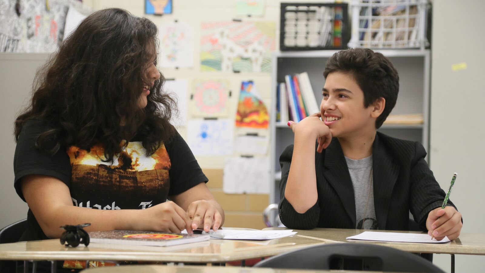 A student sits in the classroom with his teacher.