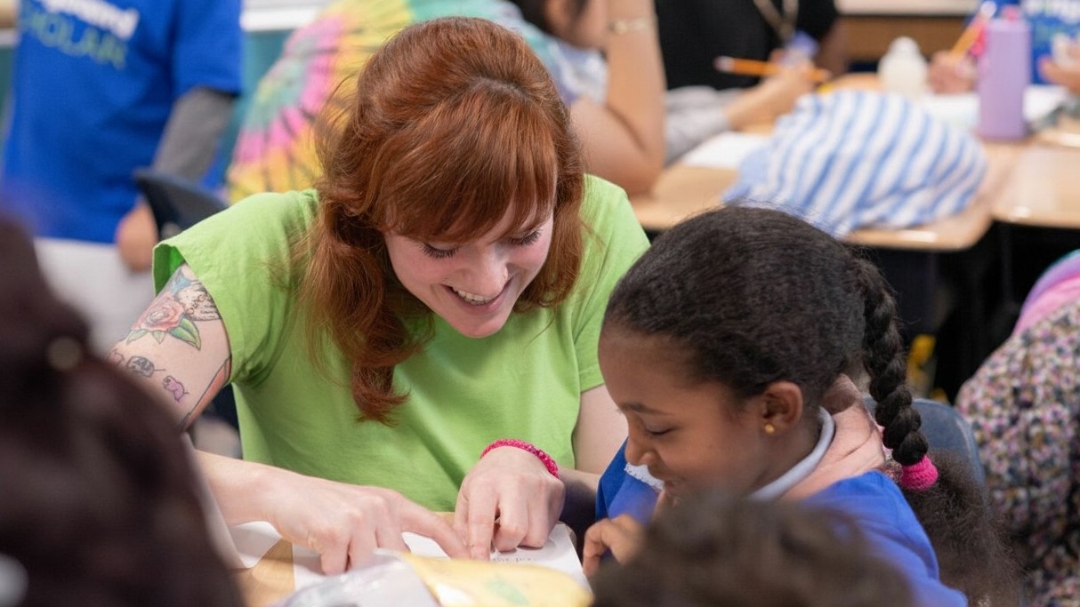 A teacher reads in class with a student.